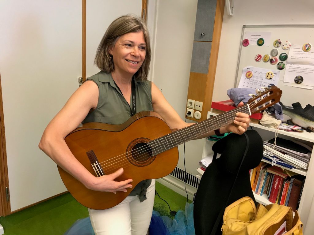 Ulrika Goude Westby, verksamhetsutvecklare på Trampolin spelar på en gitarr.